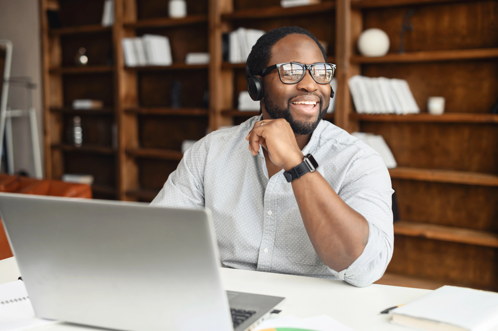 Man laughing while working on laptop