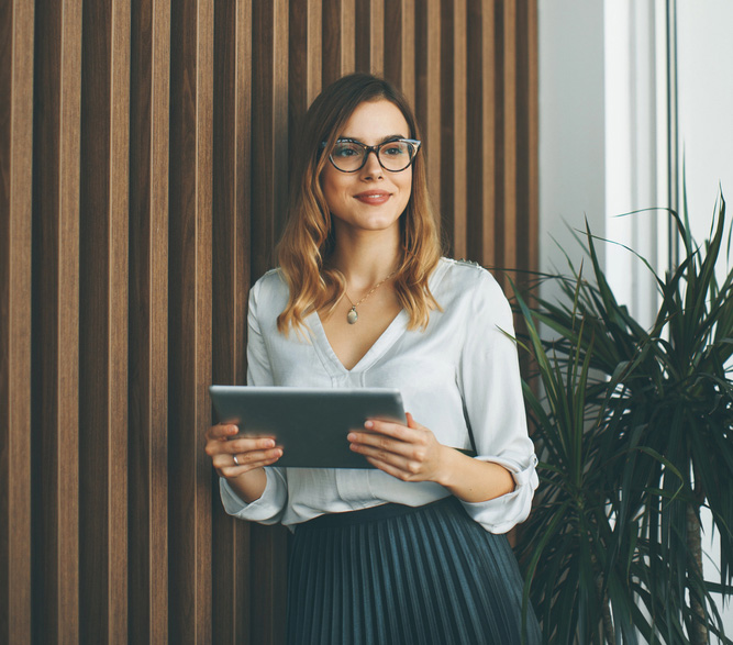 Woman holding iPad in front of trendy wall design