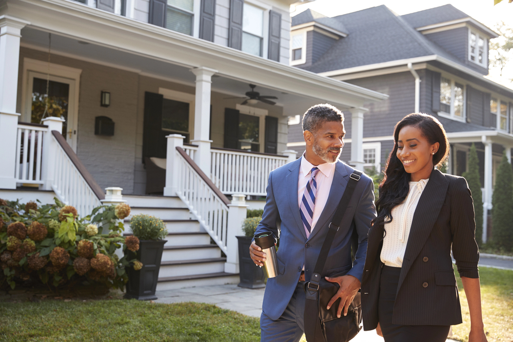 Businessman and businesswoman walking through neighborhood